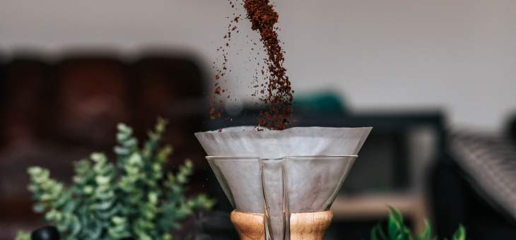 coffee-pour-into-filter-pour-over-ground-grounds-coffee-pollards-green-plants-hand